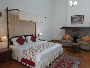 a bedroom with a large bed and a fireplace at West View Hotel in Rānīkhet