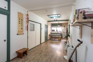 une pièce avec des murs blancs et un couloir avec une table dans l'établissement 易居の宿, à Osaka 18 autres photos