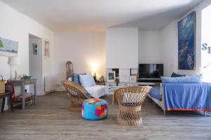 una sala de estar con un sofá y sillas en Villa Baliba, en Hyères