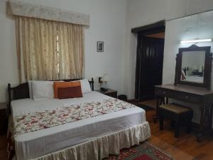 a bedroom with a bed and a dresser and a mirror at West View Hotel in Rānīkhet