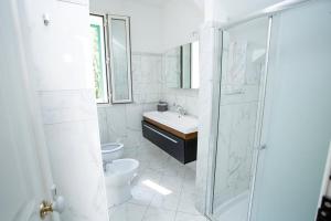 a white bathroom with a sink and a toilet at Villa Degli Angeli in Nardò
