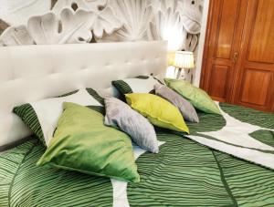 Una cama con almohadas verdes y blancas. en Tenerife Dream Apartment, en Las Galletas