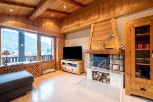 a living room with a television and a fireplace at Appartement proche La Clusaz in Saint-Jean-de-Sixt