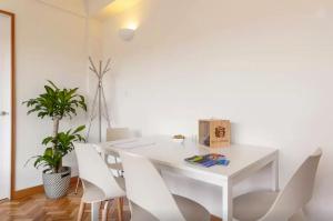 a white dining room with a white table and white chairs at Studios Baixa Downtown Porto in Porto