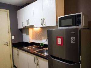 a kitchen with a refrigerator and a microwave at HOMEY MAKATI CONDO UNIT with NETFLIX in Manila
