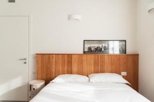 a bedroom with a bed with a wooden headboard at San Siro Fiera - Youhosty in Milan