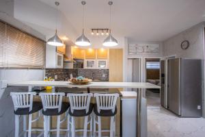 une cuisine avec un îlot et des tabourets de bar dans l'établissement Whale Rock 17, à Margate 13 autres photos