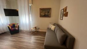 una sala de estar con un sofá y una silla en Giovy House, en Lazise