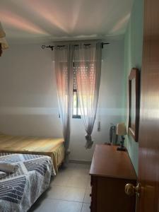 sypialnia z 2 łóżkami i oknem z zasłonami w obiekcie APART CLUB LABARROSA w mieście Chiclana de la Frontera +16 zdjęć