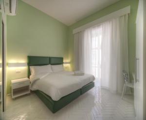 Un dormitorio con una cama grande y una ventana en New Domus Sorrento, en Sorrento