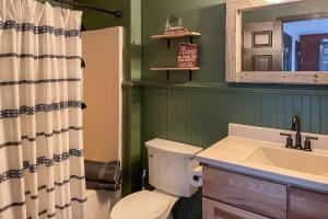 a bathroom with a toilet and a sink and a mirror at Mountain Views at Dolly's Castle Unit 7 in Sevierville