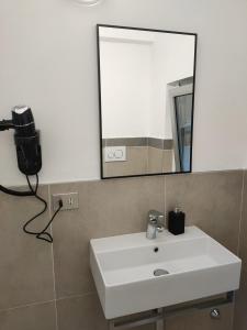 a bathroom with a white sink and a mirror at Airport Orio Studio in Bergamo +7 photos