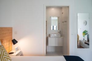 a white bathroom with a sink and a mirror at Sunflower Luxury Loft w AC Downtown and Metro in Porto +15 photos