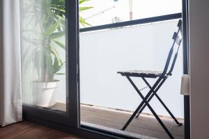a chair sitting on a balcony next to a window at Sunflower Luxury Loft w AC Downtown and Metro in Porto