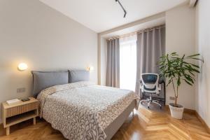 a bedroom with a bed and a chair and a plant at MiraFlora in Turin
