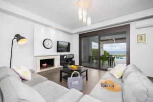 a living room with a couch and a fireplace at Villa Tsampikos in Lachania