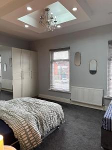 a bedroom with a bed and a chandelier at Room in Stockport Road in Manchester