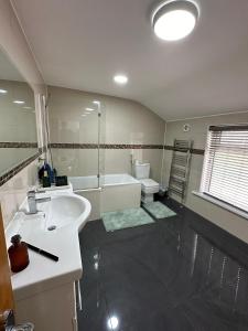 a bathroom with a sink and a tub and a toilet at Room in Stockport Road in Manchester