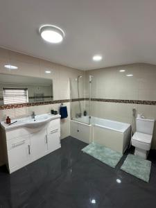 a bathroom with a sink and a tub and a toilet at Room in Stockport Road in Manchester