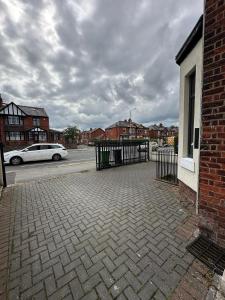 a white car parked next to a building with a gate at Room in Stockport Road in Manchester