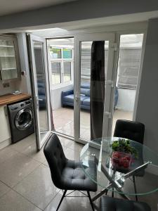 a glass table and two chairs in a living room at Room in Stockport Road in Manchester