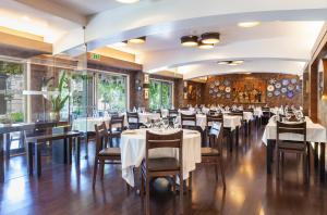a dining room with white tables and chairs at Hotel Lis Batalha in Batalha