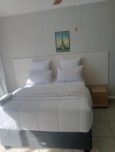a large white bed with white pillows in a room at Dne Blue Sta in Mahikeng