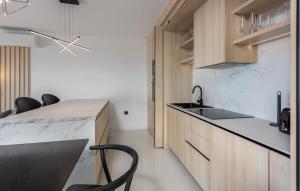 a kitchen with wooden cabinets and a sink and a counter at Gorgeous Apartment In Novi Vinodolski in Novi Vinodolski