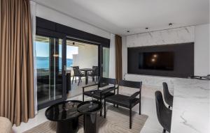 a living room with a table and chairs and a television at Beautiful Apartment In Novi Vinodolski in Novi Vinodolski