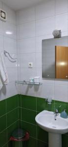 a green and white bathroom with a sink and a mirror at APARTMAN PLUS 2 Nikšić in Nikšić