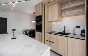 a kitchen with white marble counter tops and wooden cabinets at Nice Apartment In Novi Vinodolski in Novi Vinodolski