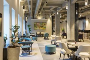 贝尔格莱德Hotel Mona Plaza的大楼内摆放着桌椅的大厅
