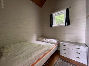 a small bedroom with a bed and a window at Selje Camping - Hytte Nr 5 in Selje