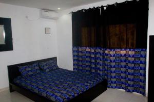 1 dormitorio con 1 cama con colcha azul en Agréable Mini-Studio Meublé avec Wifi Gratuit, Climatiseur et Eau Chaude à Disposition, en Dakar 5 fotos más