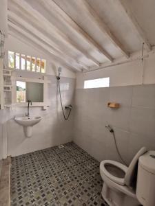 a bathroom with a toilet and a sink at Exotic house in Gili Meno