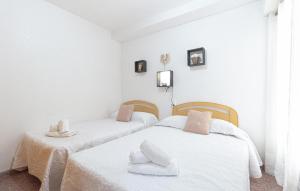 two beds in a room with white walls at Awesome Apartment In Torrevieja in Torrevieja
