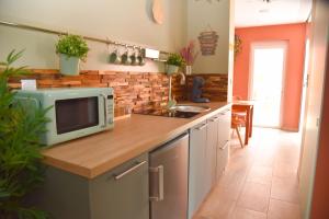 a kitchen with a counter with a microwave on it at SPA rêve nature in Calais
