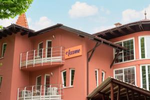 a pink building with a sign that reads orange at Accomo Apartmanház in Siófok
