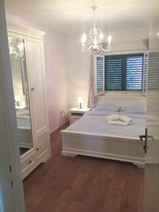 una camera da letto con un letto con un lampadario a braccio e uno specchio di Apartments Damir - Katarina a Sutivan (San Giovanni di Brazza)