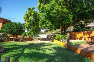 a green yard with a tree and a fence at Pousada Moinho D'água in Guarapari