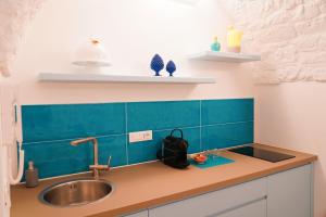 a kitchen counter with a sink and blue tiles at Casetta Bouganville - con TERRAZZA PANORAMICA in Ostuni