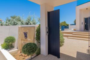 a door to a villa with a sign on a wall at Ventus Villa - A Luxury Sea View Retreat in Akrotiri in Akrotiri