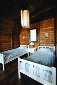 two beds in a room with wooden walls at Mora Farmhouse in Ardeşen