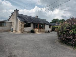 a house with a driveway in front of it at Drumgauty Cottage in Strabane