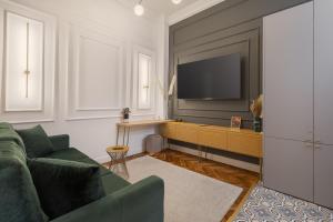a living room with a green couch and a television at Olimpia Residence in Oradea