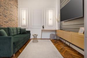 a living room with a green couch and a flat screen tv at Olimpia Residence in Oradea