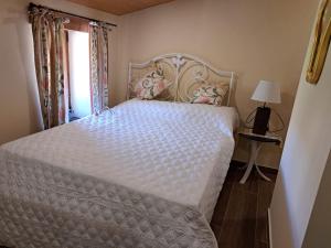 a bedroom with a white bed and a window at Casa Alice - Aldeias do Xisto - Sobral de Sao Miguel in Sobral de São Miguel