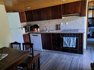 a kitchen with a sink and a refrigerator and a table at Casa Alice - Aldeias do Xisto - Sobral de Sao Miguel in Sobral de São Miguel