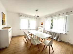una sala da pranzo con tavolo e sedie bianchi di Charmante maison Molsheim a Molsheim