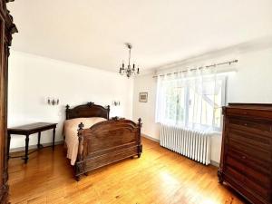 una camera da letto con un letto di legno e una finestra di Charmante maison Molsheim a Molsheim